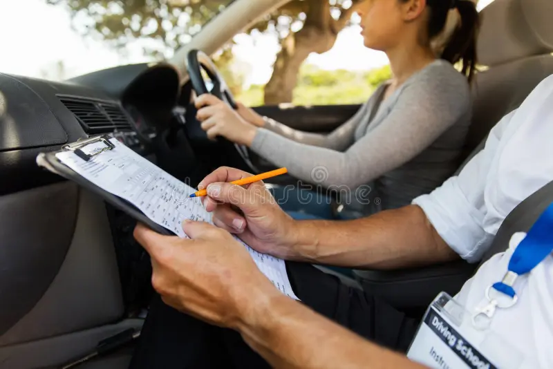 driving-instructor-student-driver-inside-car-doing-checklist-65407116